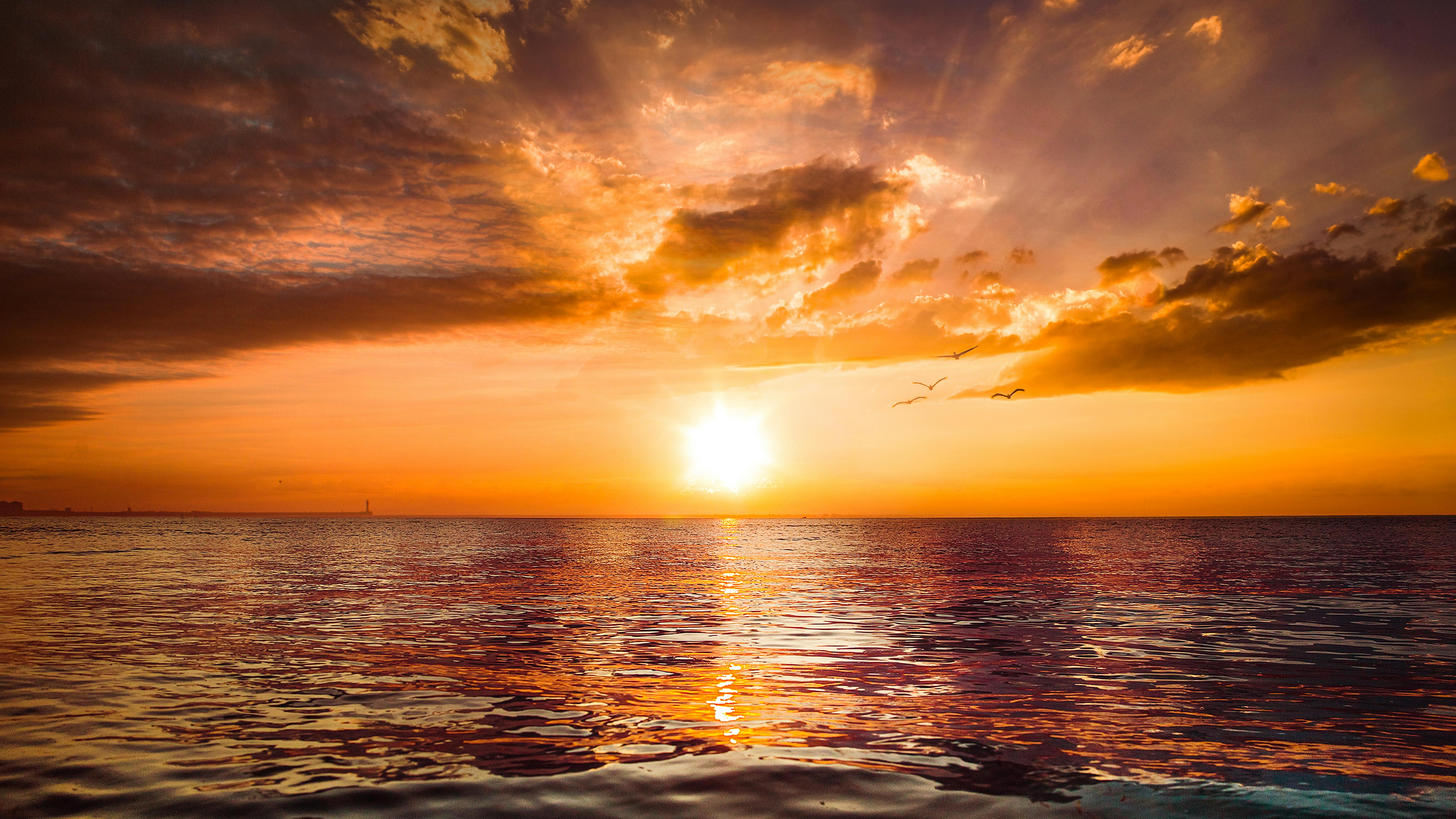 Powerful ocean waves under a dramatic golden and purple sunset sky